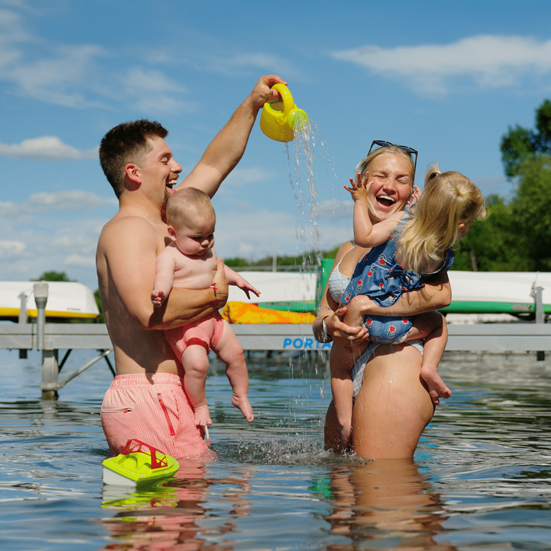 Family playing in the lake beside a Porta-Dock dock, from a brand video shoot directed by Moxie Creative