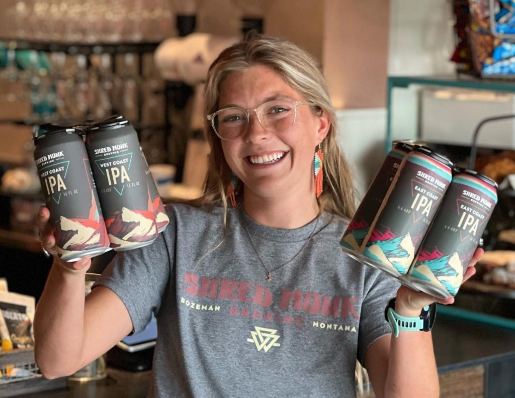 Woman holding Shred Monk IPA cans with packaging designed by Moxie Creative
